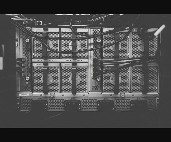 Dark-mode photo of a server chassis with cooling fans and dense cabling.